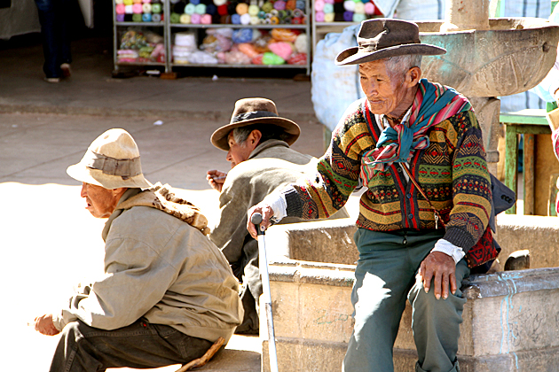 Quechua Man sitting at a stone fountain in Sucre, Bolivia